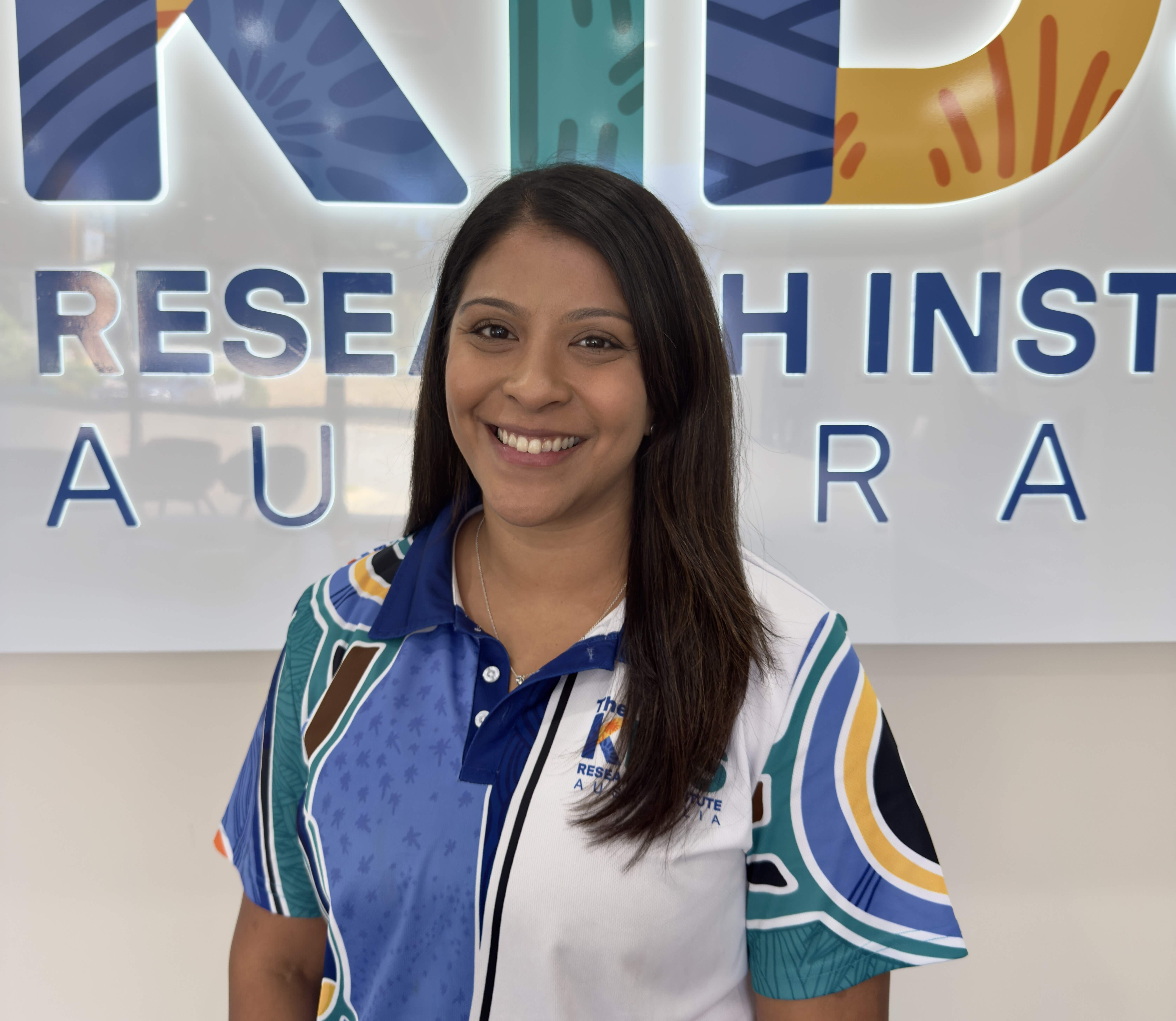 Alexis Harun headshot in front of The Kids sign